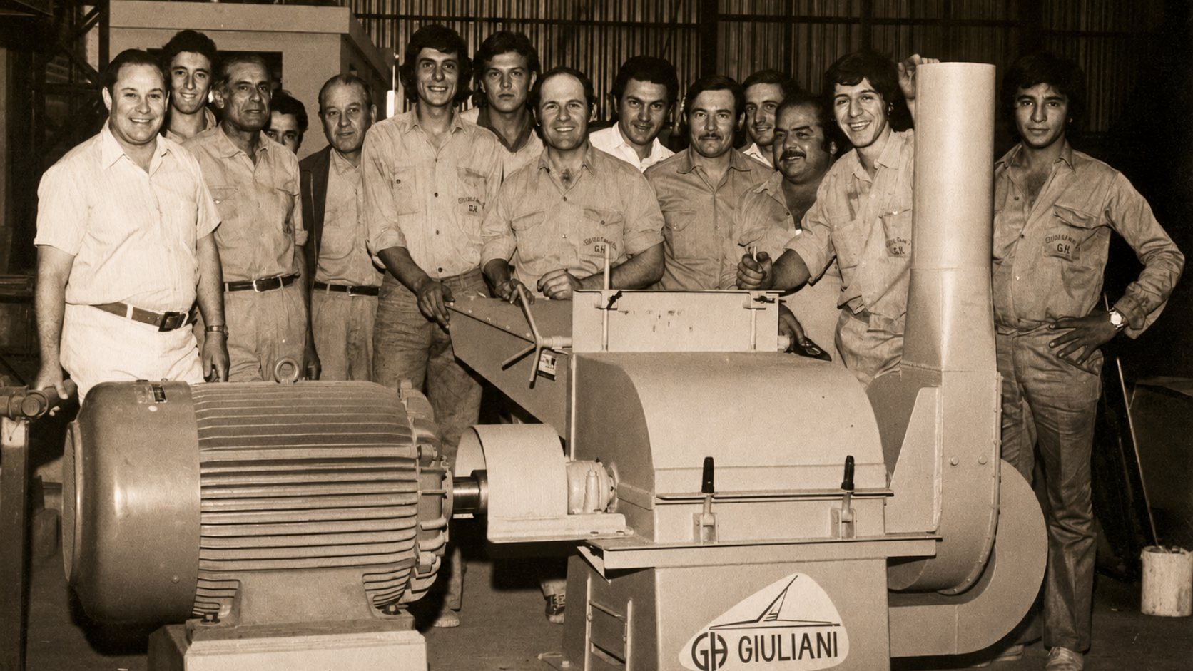 Personal de Giuliani Hermanos junto a un molino de martillos con la marca Giuliani y su motor