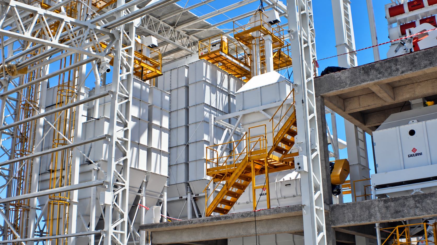 A Giuliani feed mill under erection, with process tower, walkways and yellow stairs